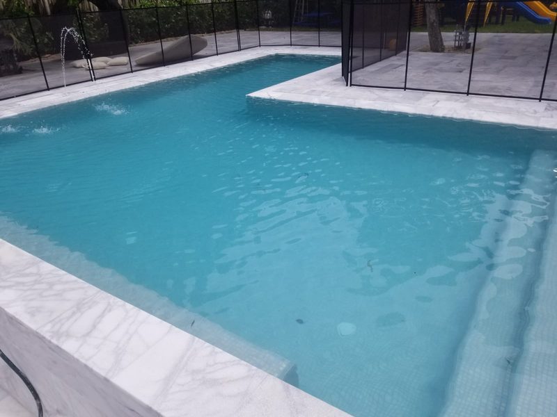 Geometric pool with step entry and safety fence in Cape Coral