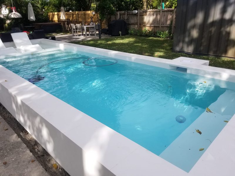 Pool with raised dark-tile spa and safety fence in Miami